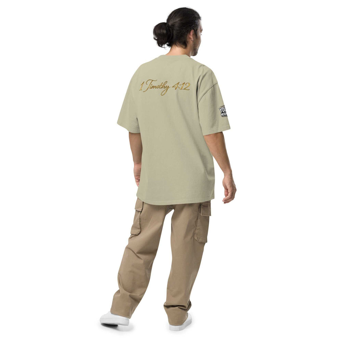 Man wearing oversized signature tee in relaxed streetwear style against plain background
